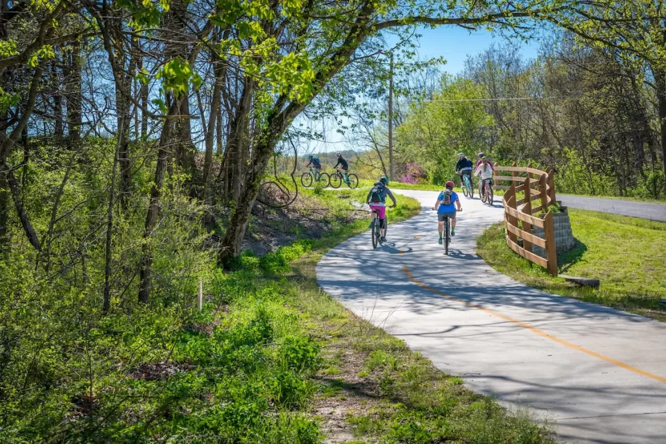 People biking on paved bike trail in Arkansas.